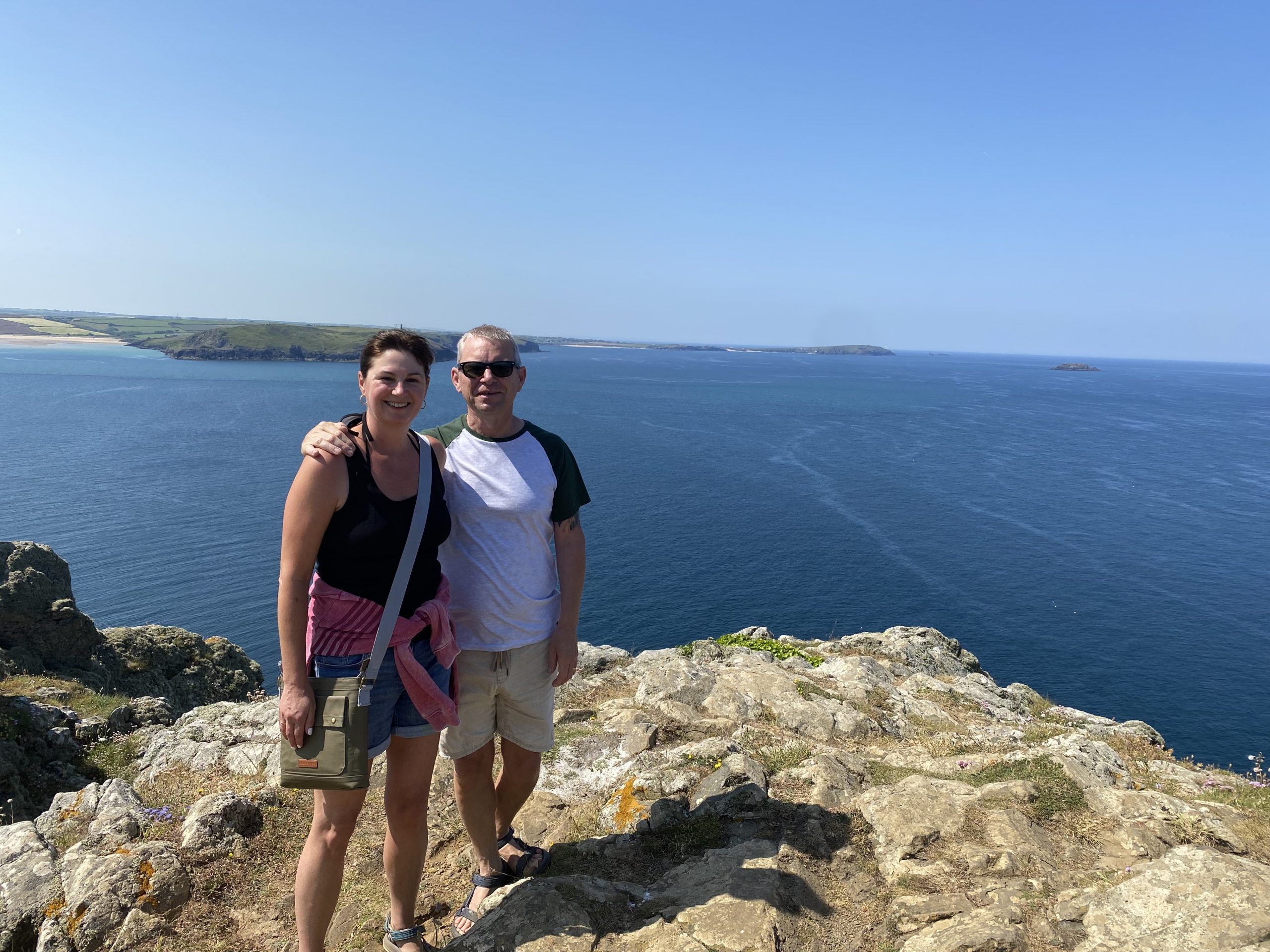 Pat's son Matt with his wife Sarah standing on cliff by the sea during hike