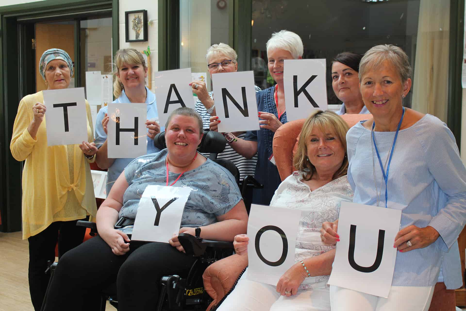 Hospice patients and nurses holding a sign that reads "Thank You".