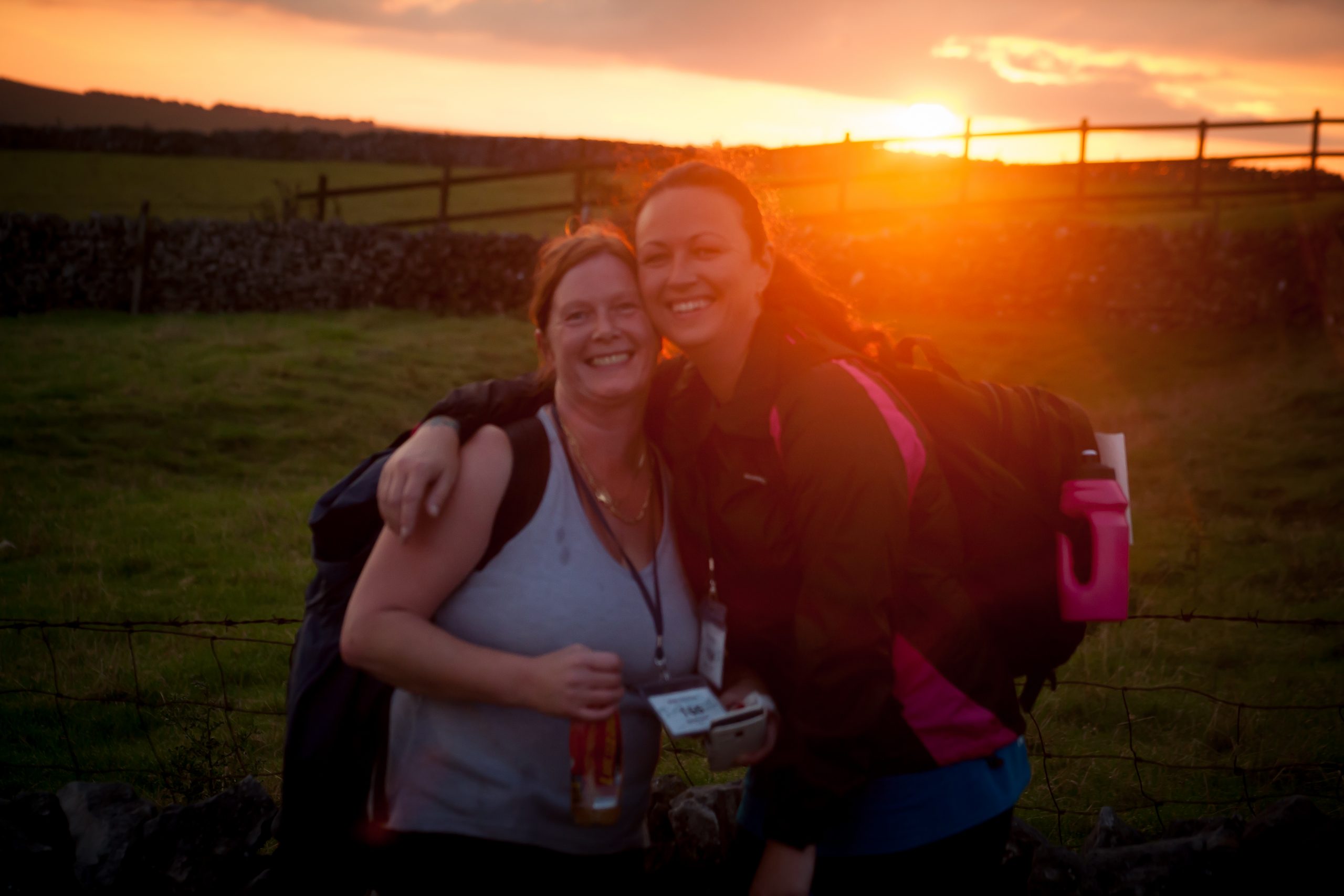Snowdon-2014_KHH-Challenge_001 Two ladies pictured in green fields in front of a sunrise