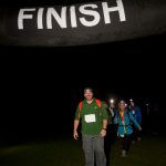 Snowdon at Night challenge hikers crossing the finish line in the dark and smiling.