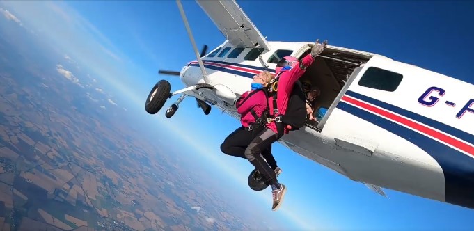 Tandem skydivers jumping out of a plane.