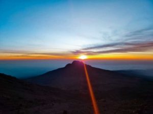 The sun rising over a blanket of fluffy cloud, and Mawenzi.