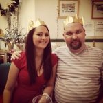 Holly (left) and her father (right) pictured at Christmas wearing paper hats.