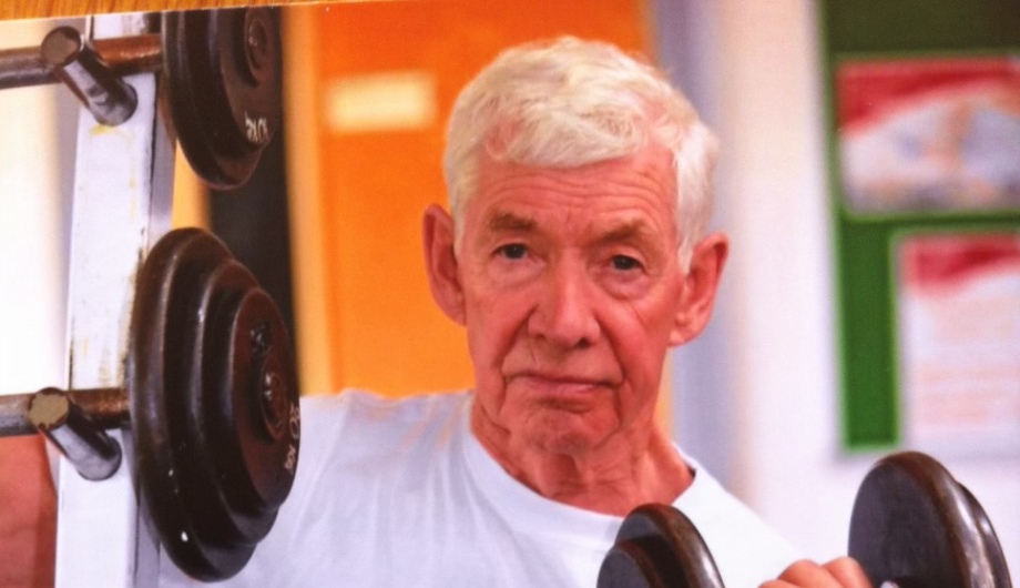 Close up of Patrick Harvey lifting weights.