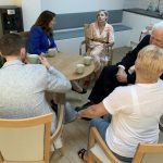 Stafford MP Theo Clarke sits talking with staff and patients