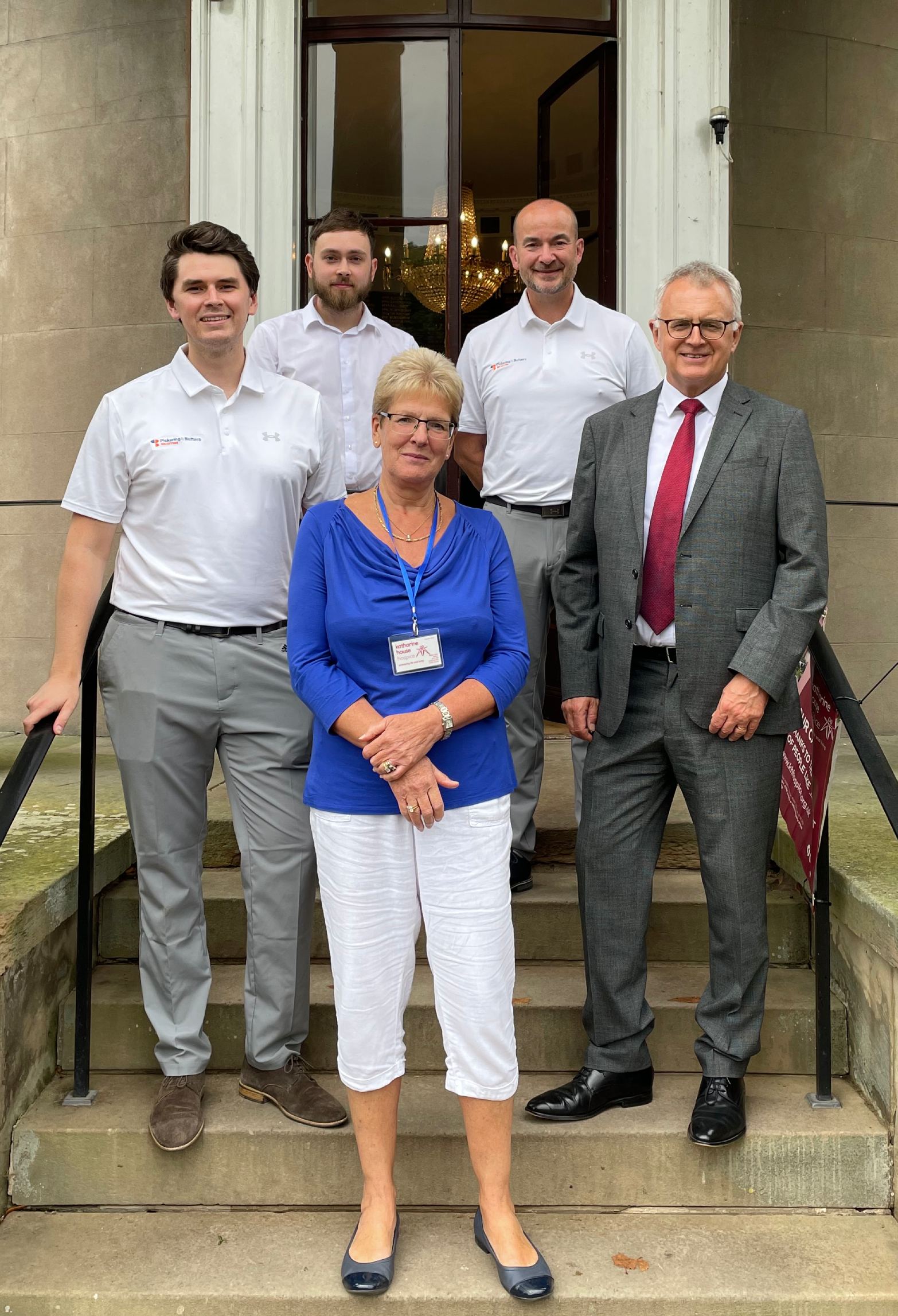 Stephanie Harris, Katharine House Hospice Vice-chairman of Trustees, standing with four male representatives of Picking and Butters Solicitors, Stafford.