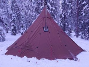 A red teepee tent in the snow.