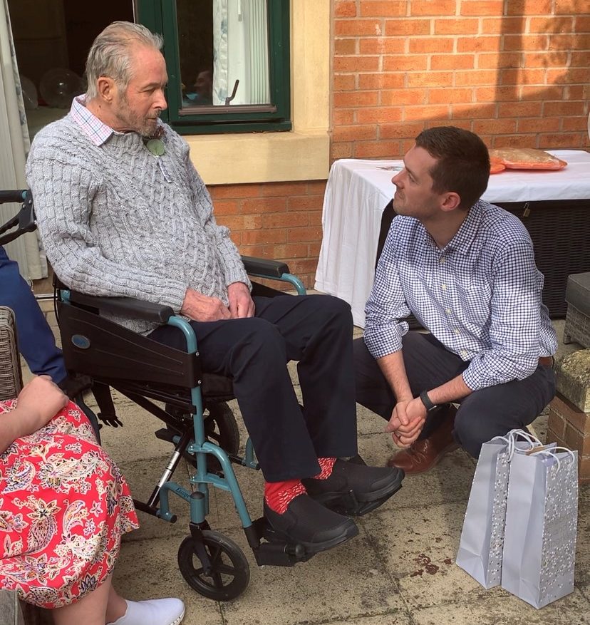 Director of Care, David Fletcher, congratulates the happy couple and gifts them two bottles of bubbly.