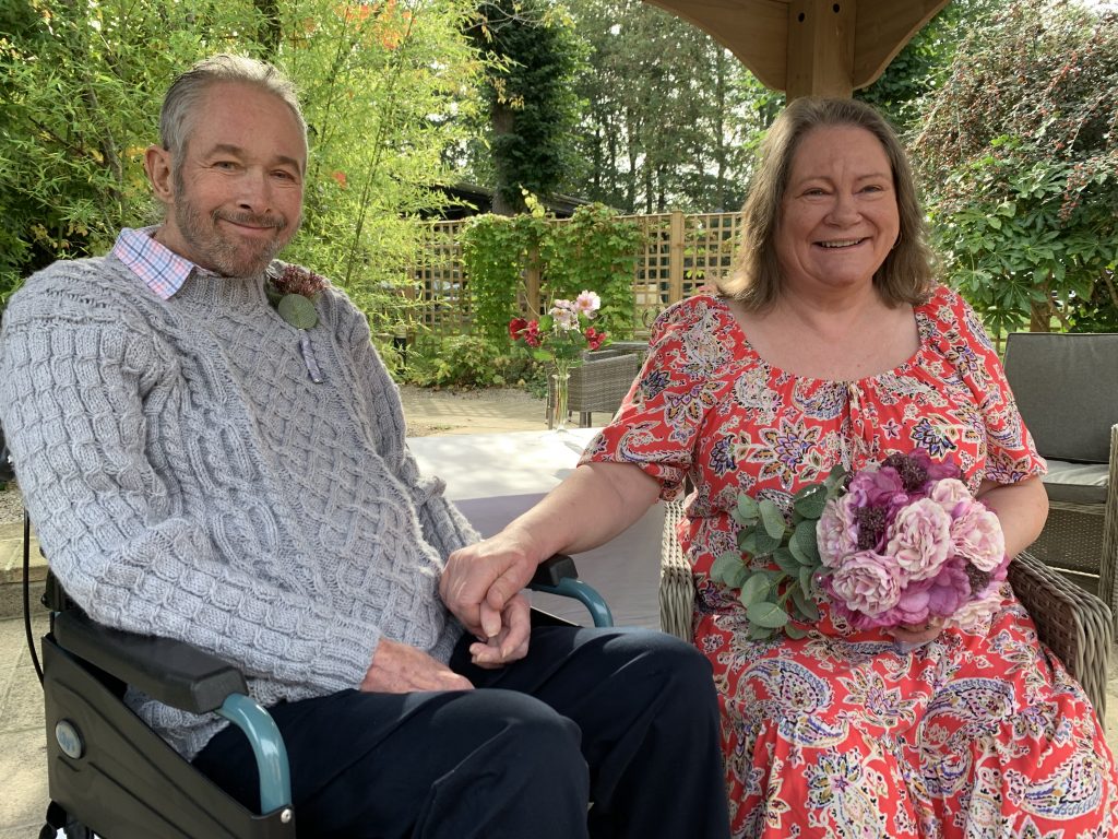 Philip and Yvonne hold hands with big smiles after getting married.