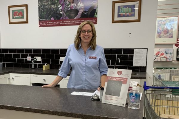 Eccleshall shop manager Mel smiling stood behind the donation point counter