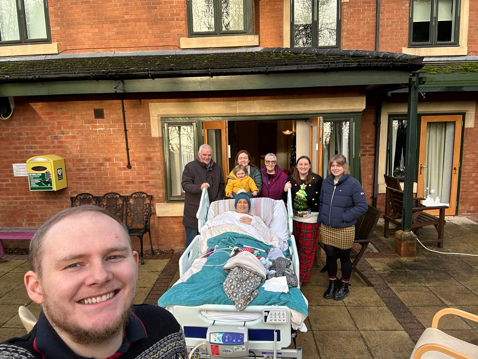 Marie in her bed outdoors with her family on Christmas Day at the hospice.