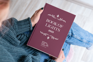 Person holding the Book of Lights from Katharine House Hospice.