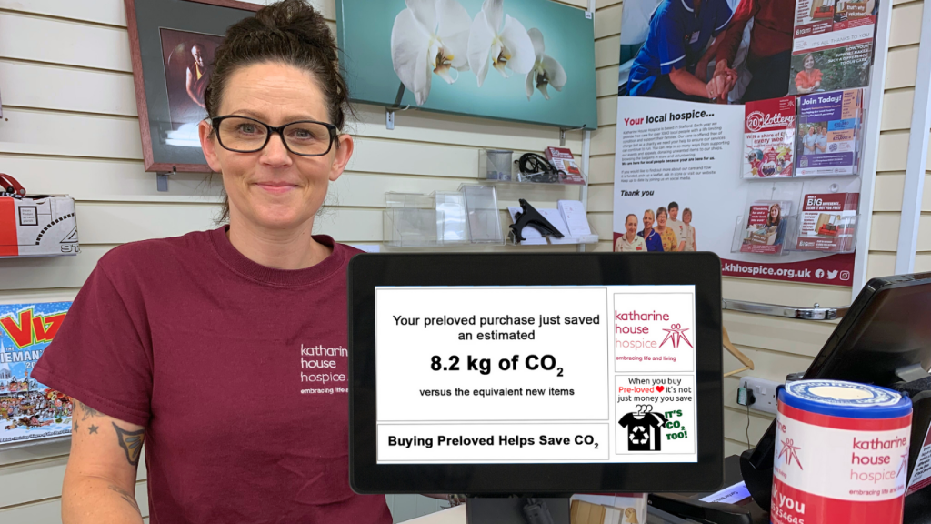 Retail Assistant, Tammy, stands behind the till displaying the CO2 savings of a recent purchase.