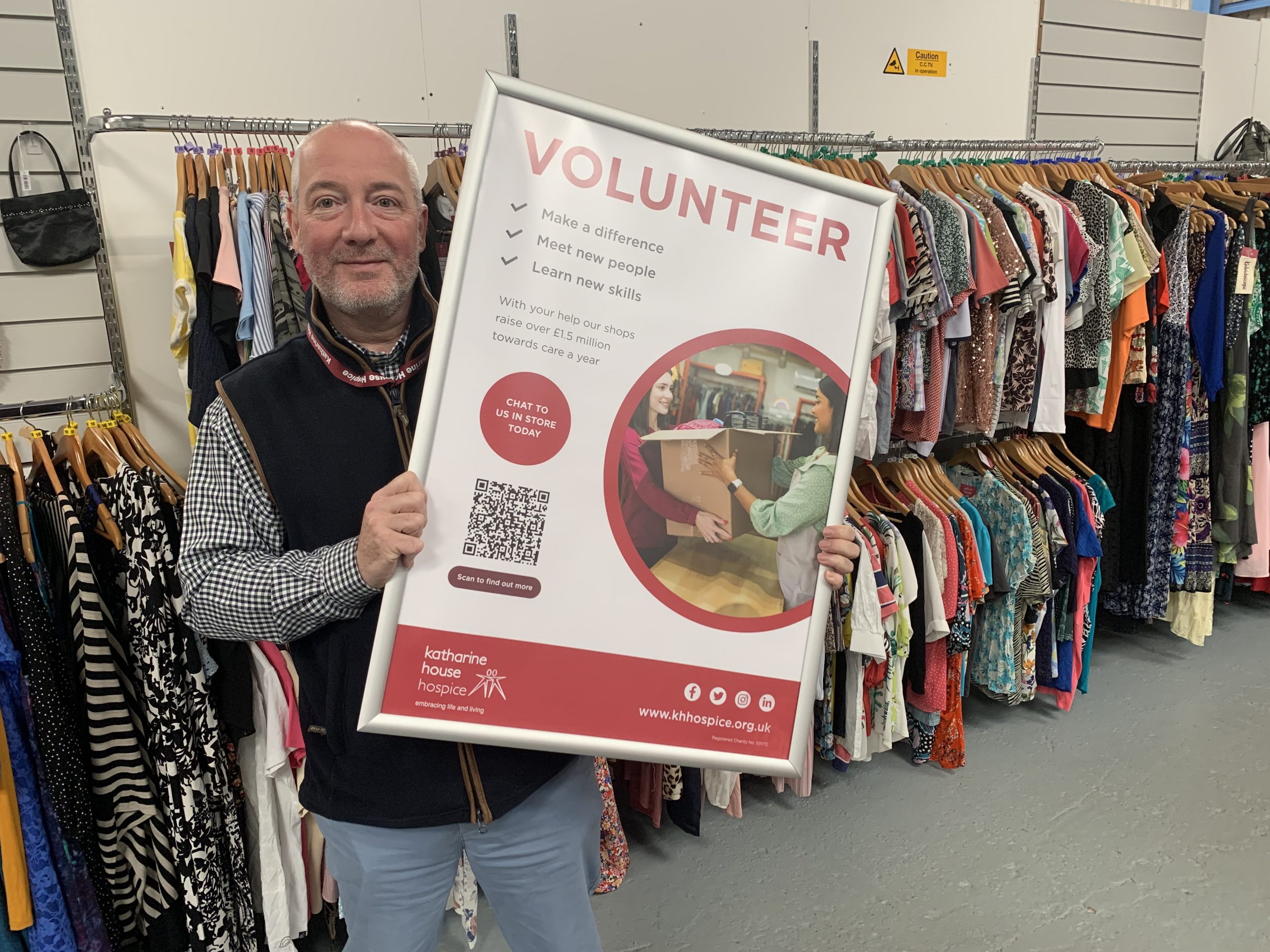 Retail Support Manager, Dave, holds up a volunteer poster.