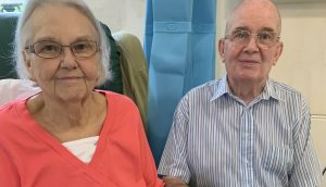 Woman and man sat smiling next to each other