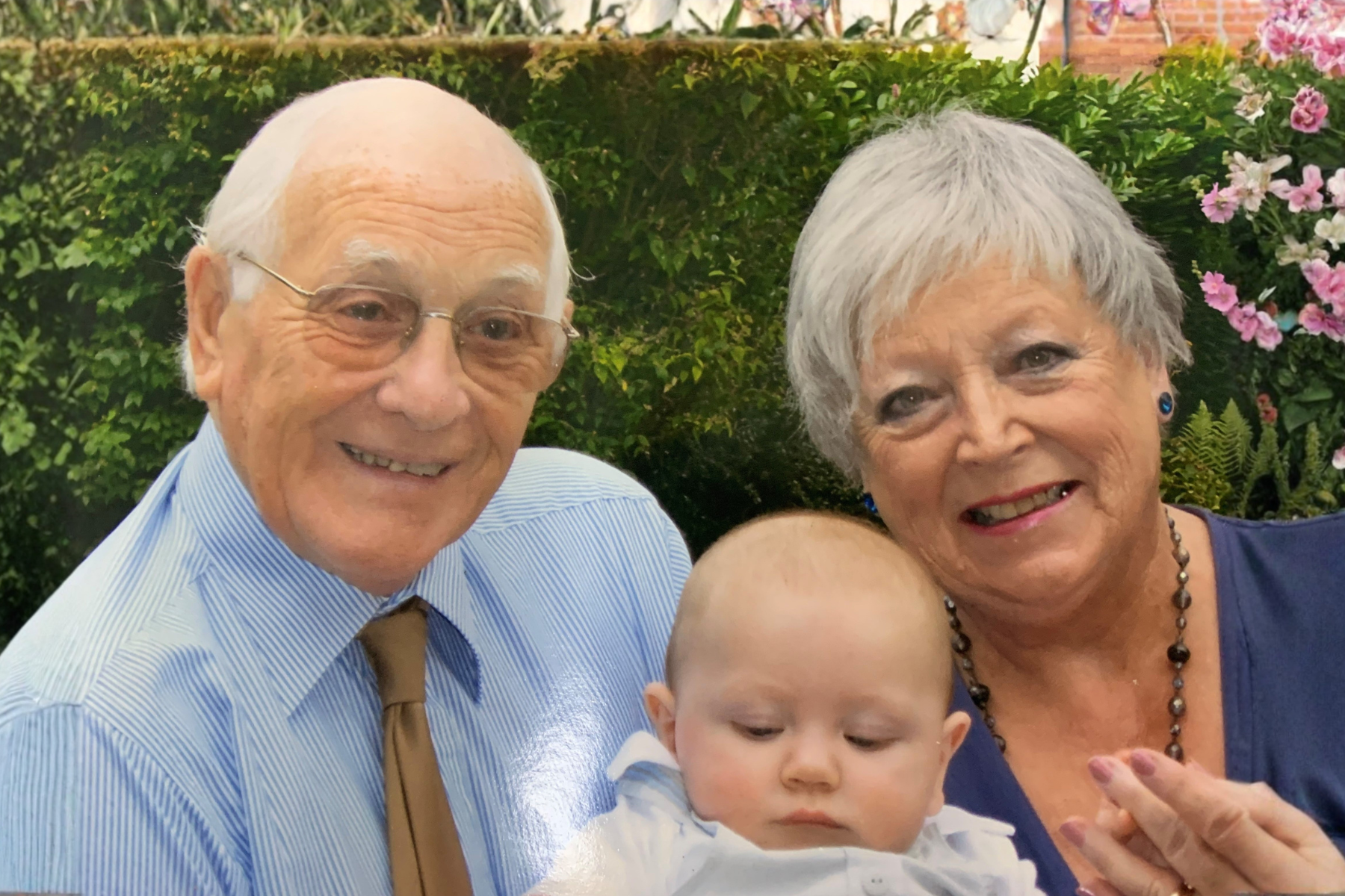 A couple of grandparents holding a baby.