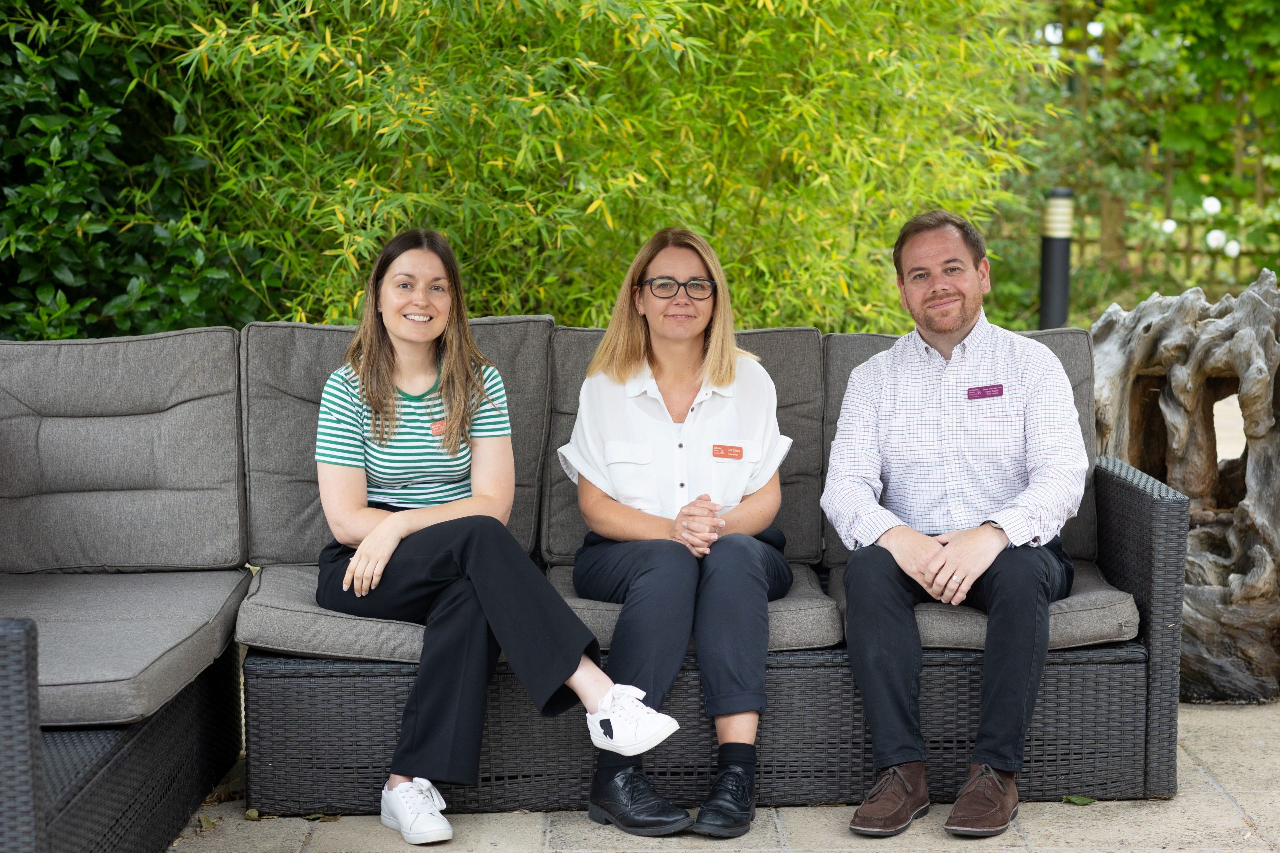 FST group pic Our Family Support Team (L-R: Hannah, Deb and Javier) sitting together outside smiling to camera.