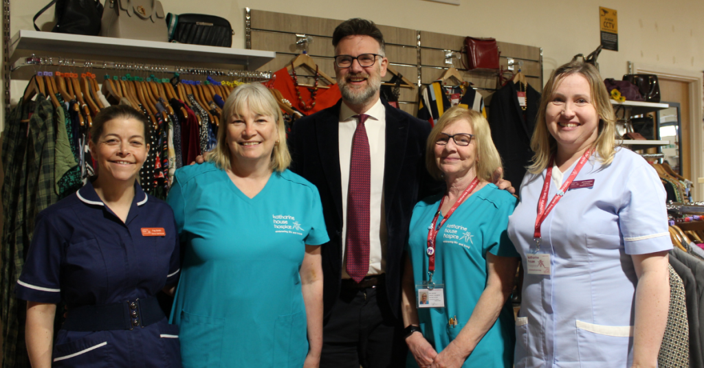 TV presenter, Charles Hanson standing with four Katharine House Hospice care staff inside the Rugeley shop