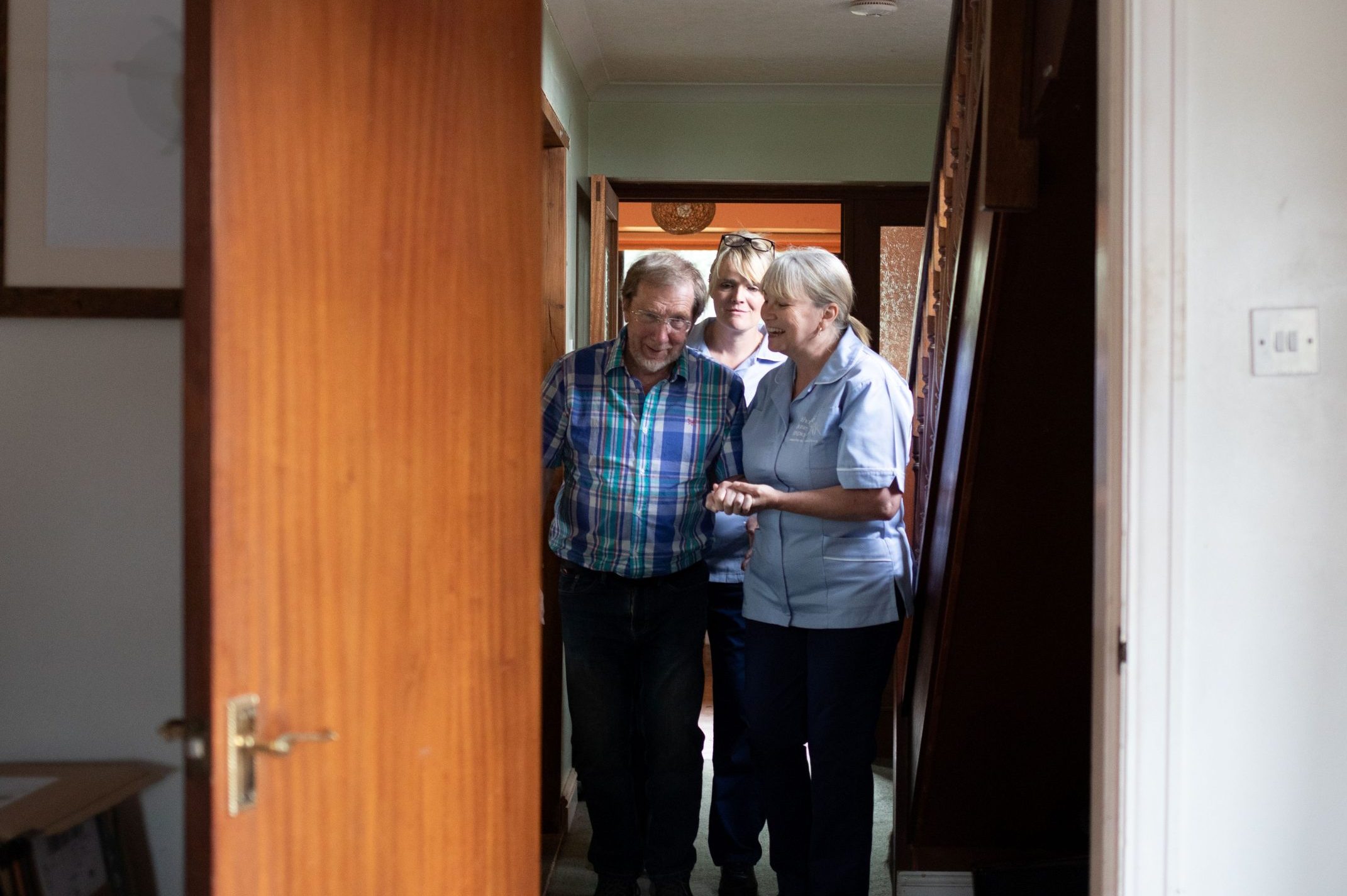 Hospice care at home (4) Nurse assisting a patient walking back to his seat.