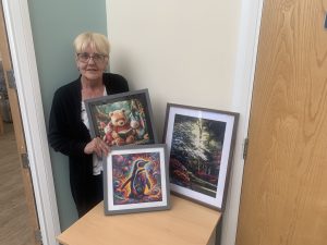 Wendy with a collection of her diamond art pictures