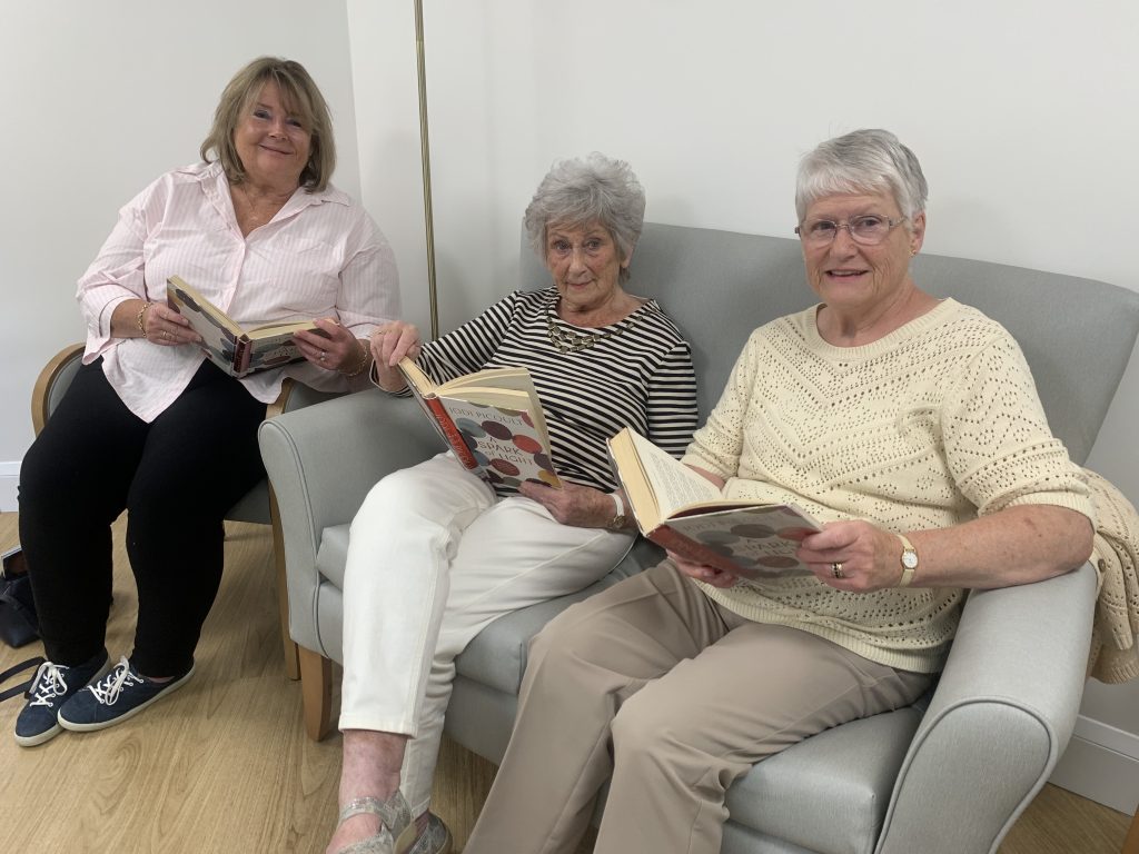 Three members of the book club sitting together with books
