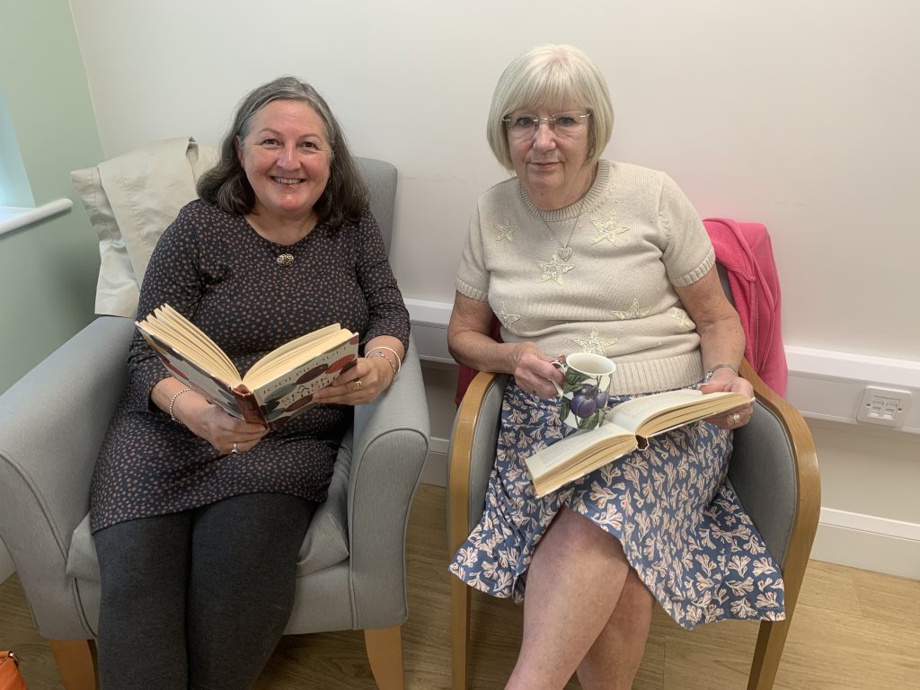 Two members of the book club sitting together with books