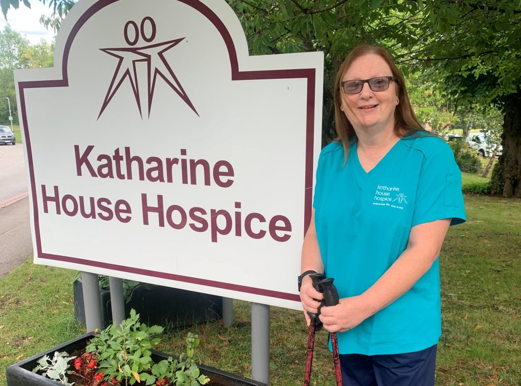 Care worker in uniform standing in the hospice garden