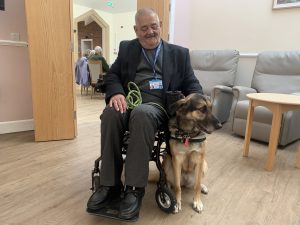 Gentleman in a wheelchair with his German Shepherd-Husky cross assistance dog.