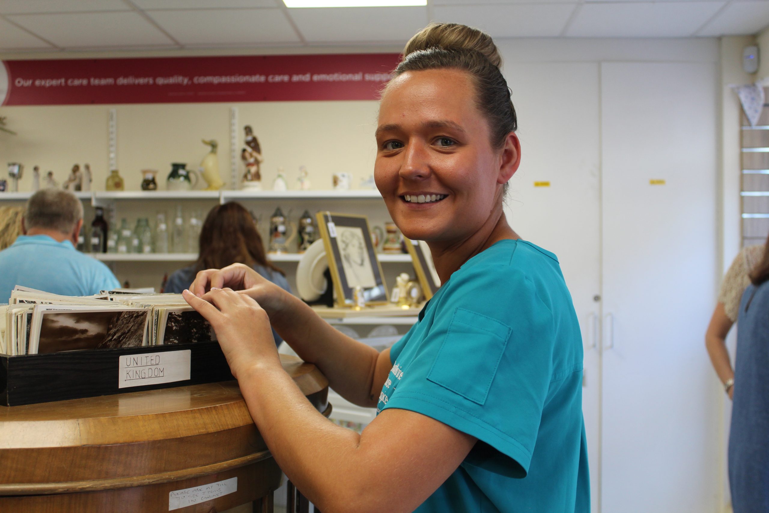 IMG_1677 A hospice at home nurse in our charity shop, smiling to camera.