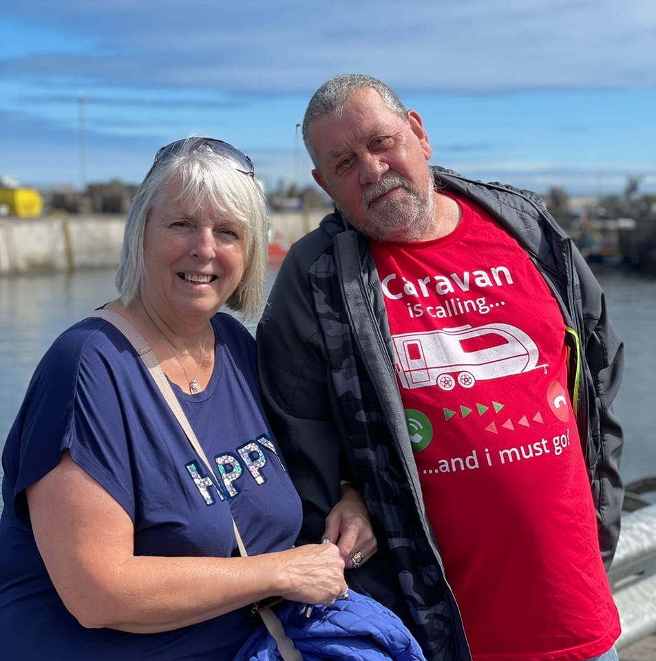 Couple smiling in a holiday setting.