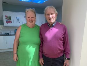 Father and daughter, Alan and Lorraine Ramsay stand side by side smiling. 