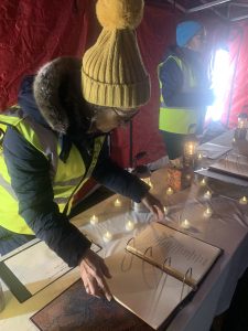 IMG_6080 A volunteer shows off the book of lights surrounded by tealights
