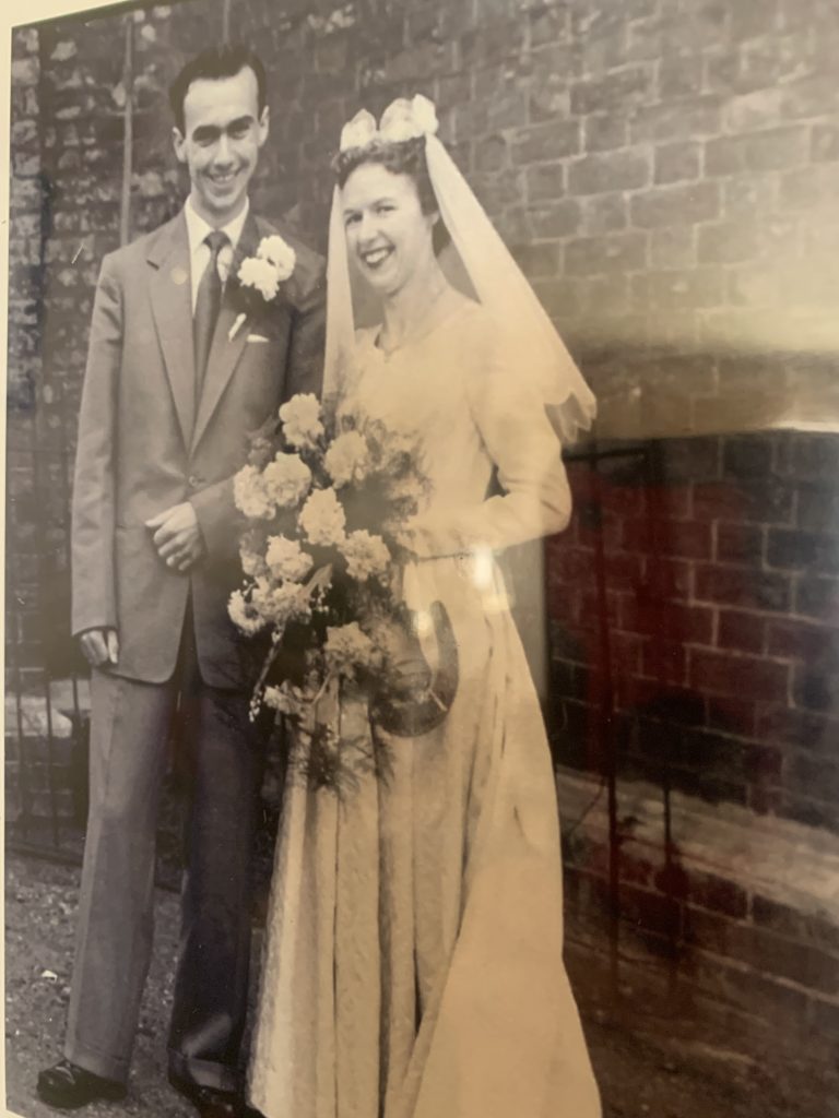 A bride and groom on their wedding day, looking exceptionally happy.