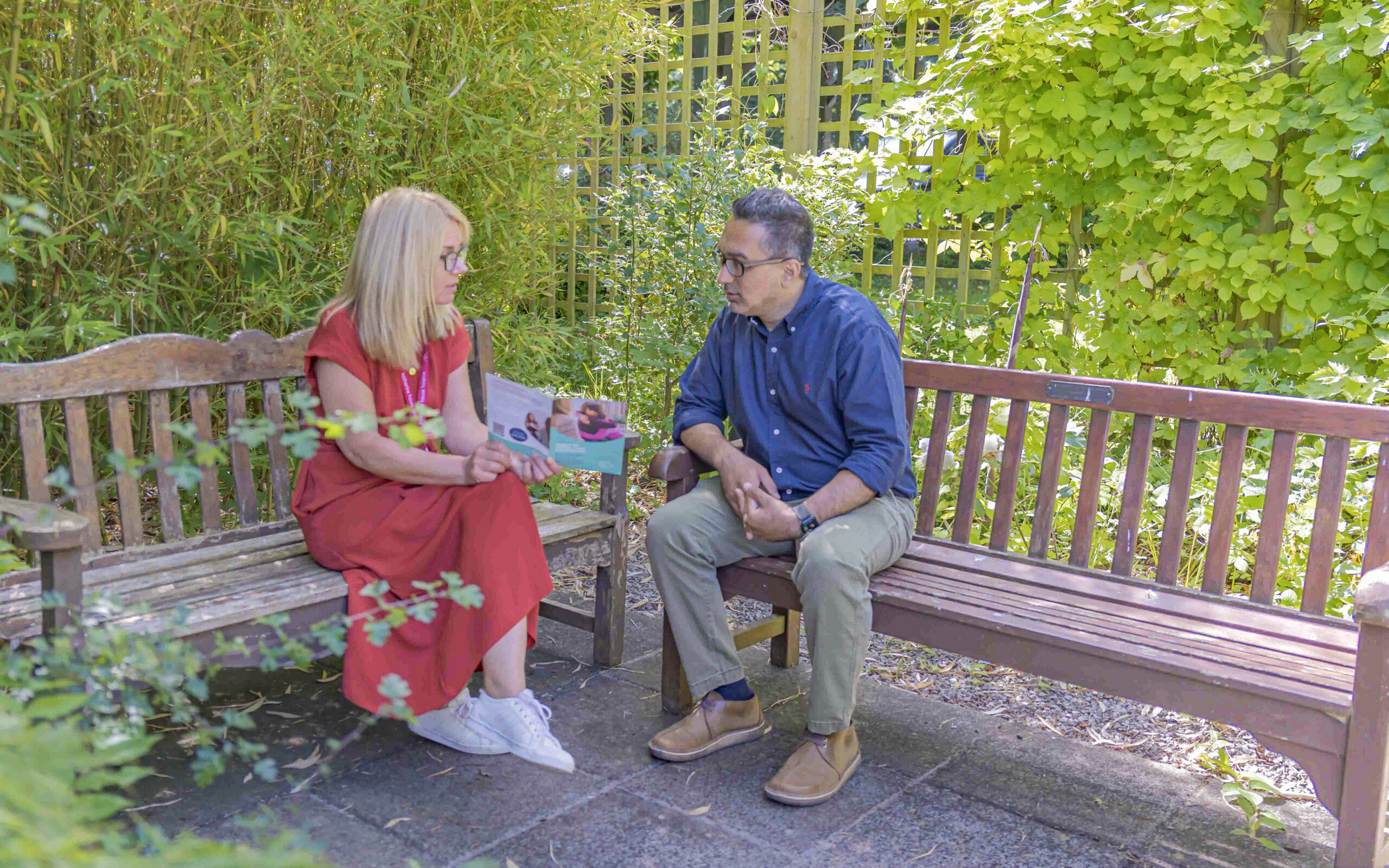 A man talking to a counsellor in a private outdoor area.