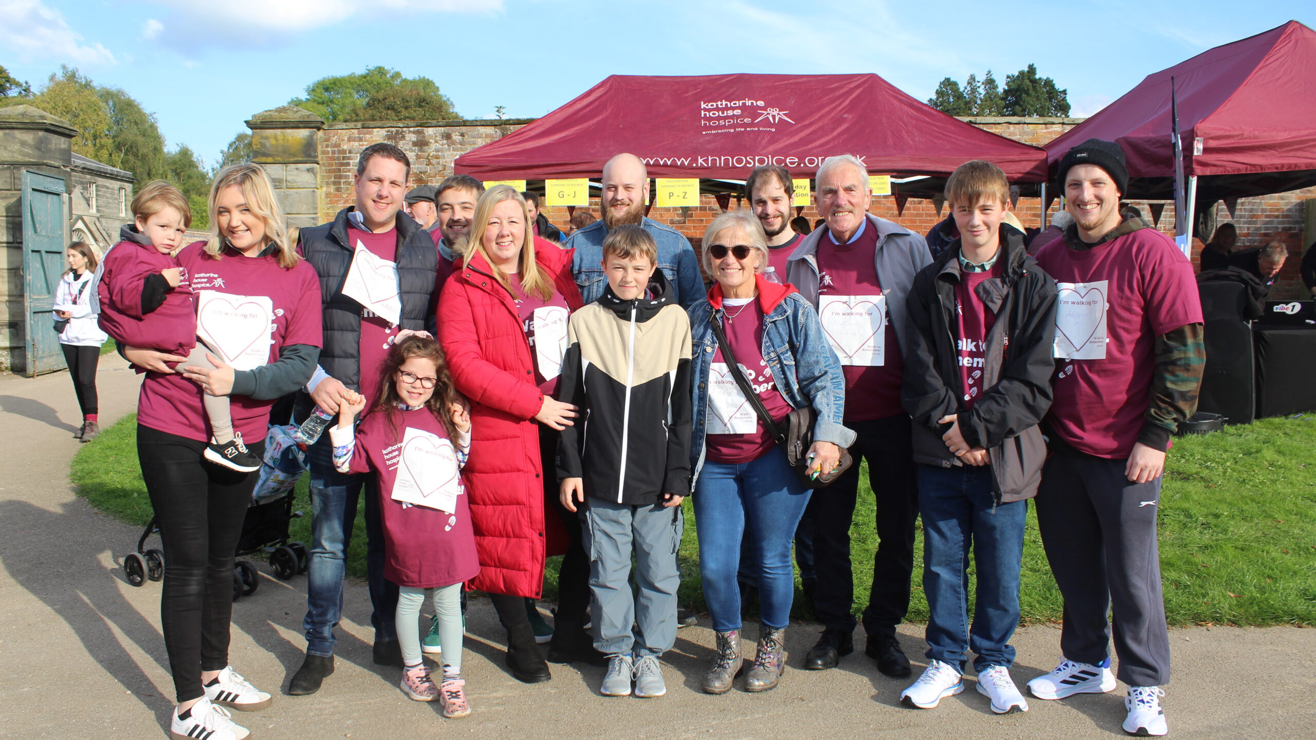 A large mixed multi-generational family group wearing event T-shirts.