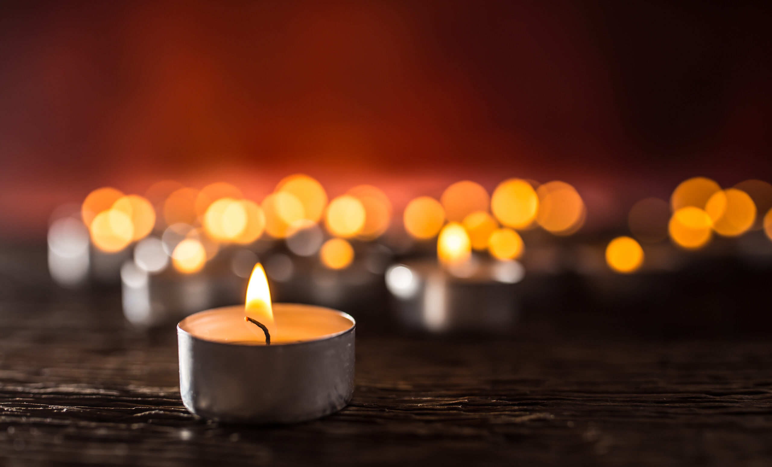 Many candles burning bright at night, symbolising remembrance.