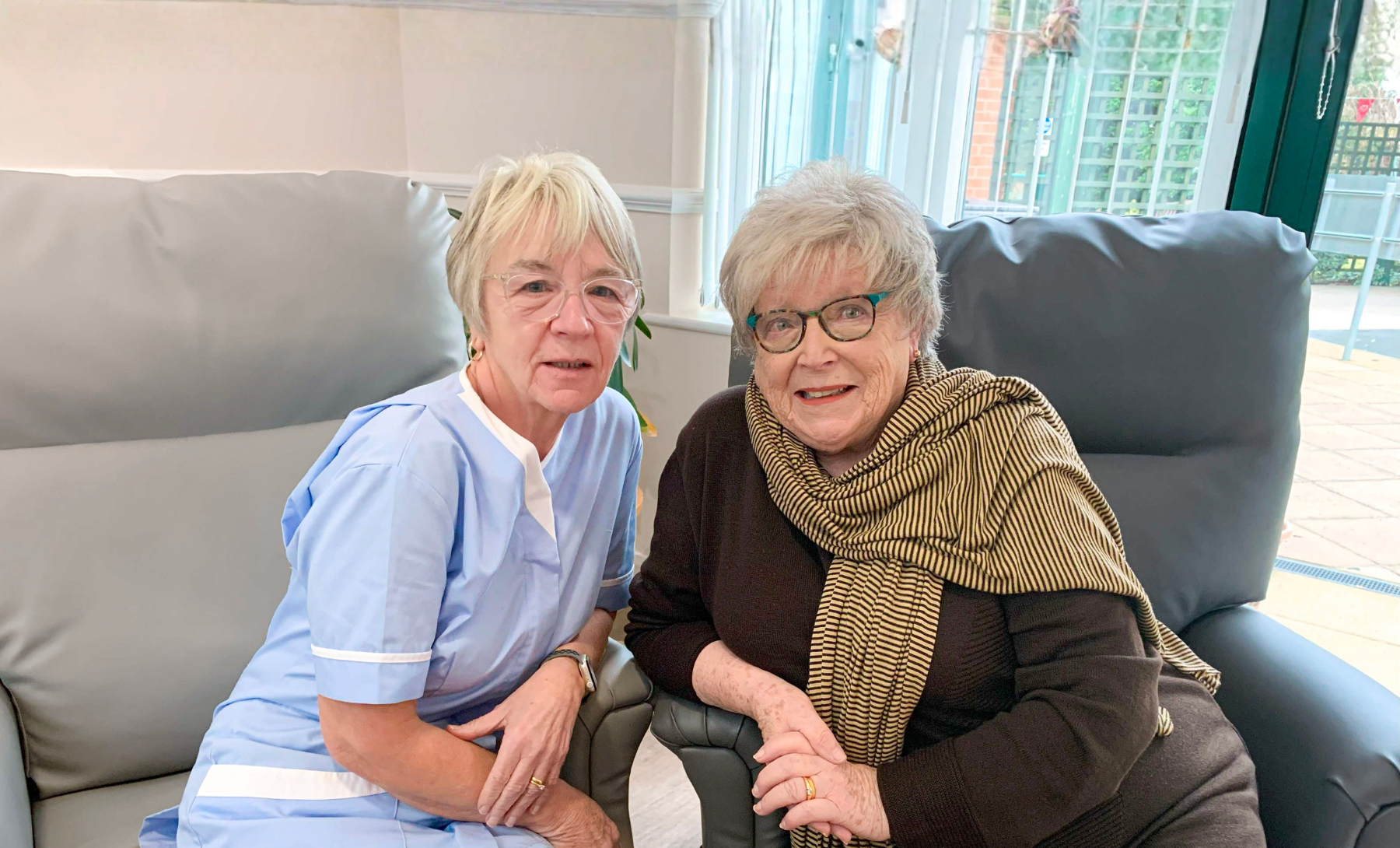 Healthcare Assistant, June, with patient Ann. Both smiling.