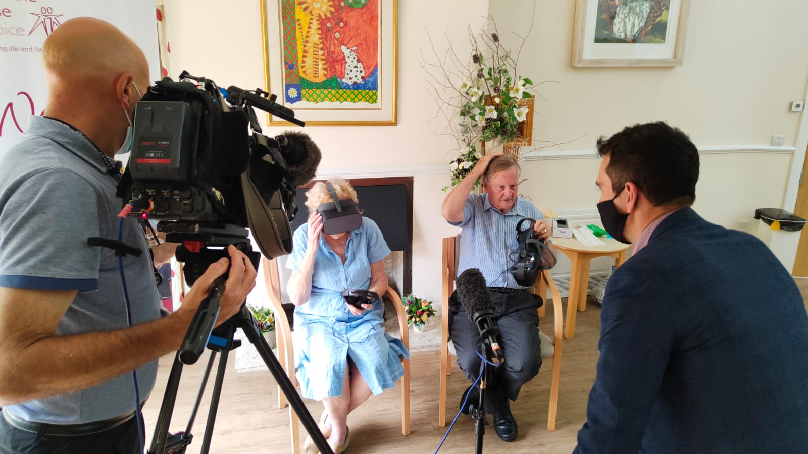 Camera crew filming two people using VR headsets.