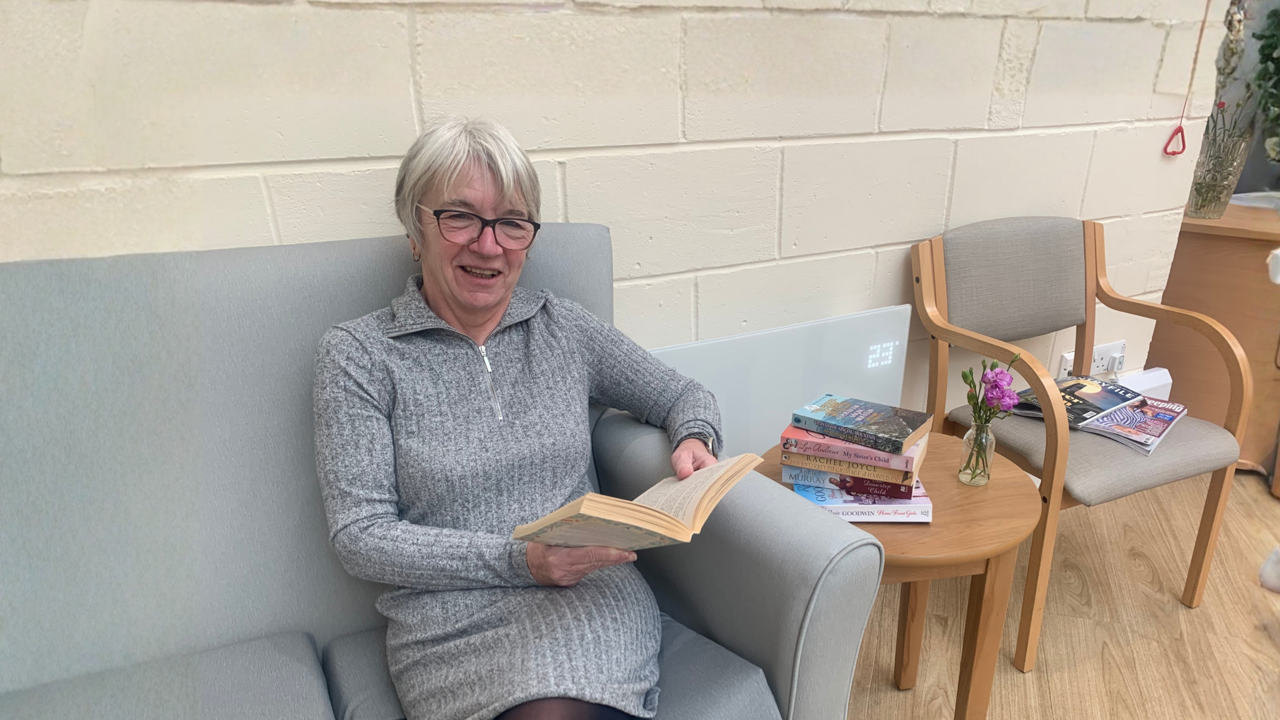 A woman sitting reading a book.