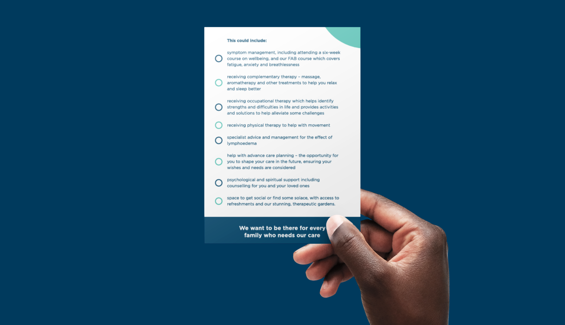 Close up of hands holding a leaflet that lists a range of specialist services such as complementary therapy.