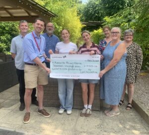 A group of people holding a big cheque for over £17,000.
