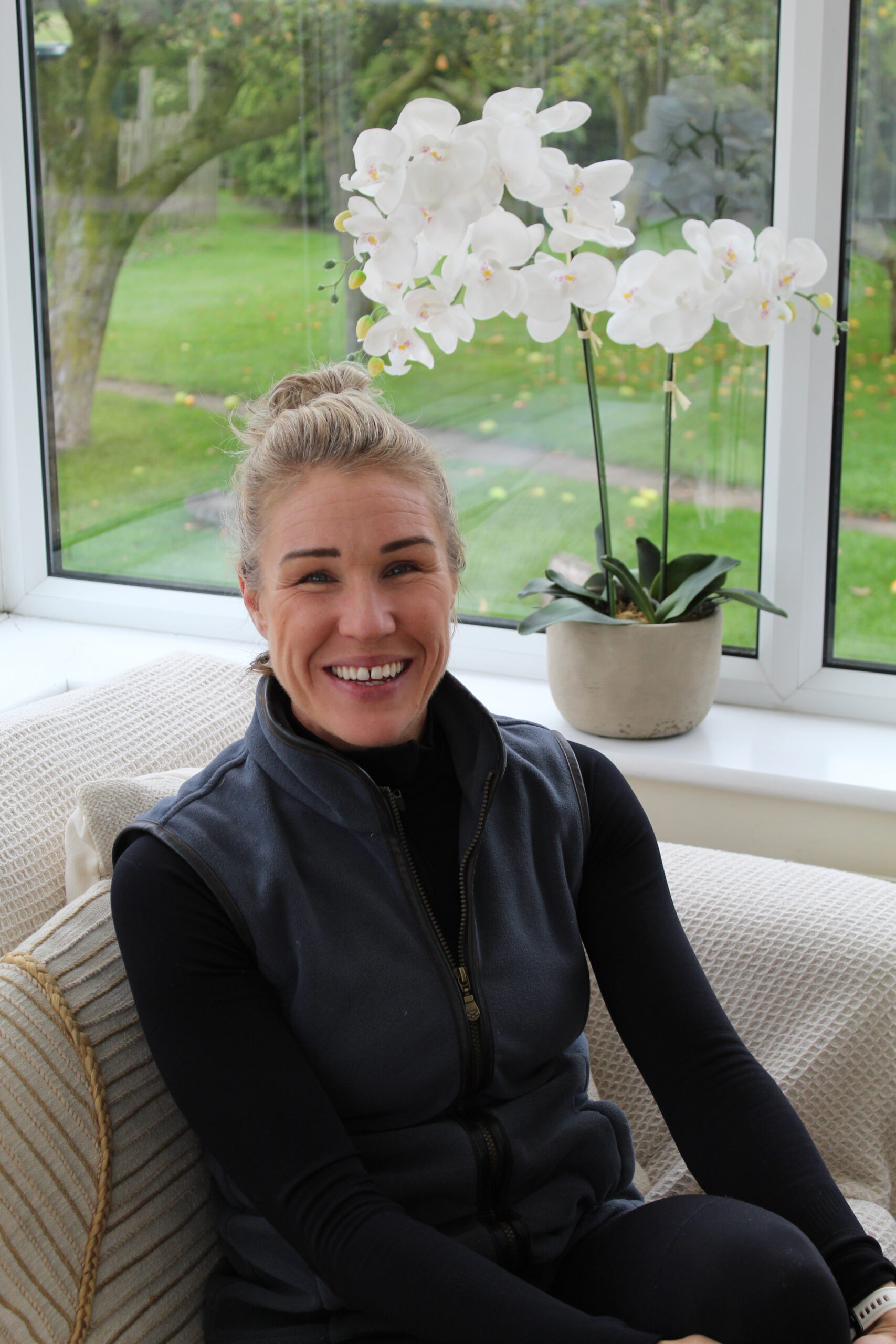 Emily smiling as she sits in the conservatory at Far Coley Farm