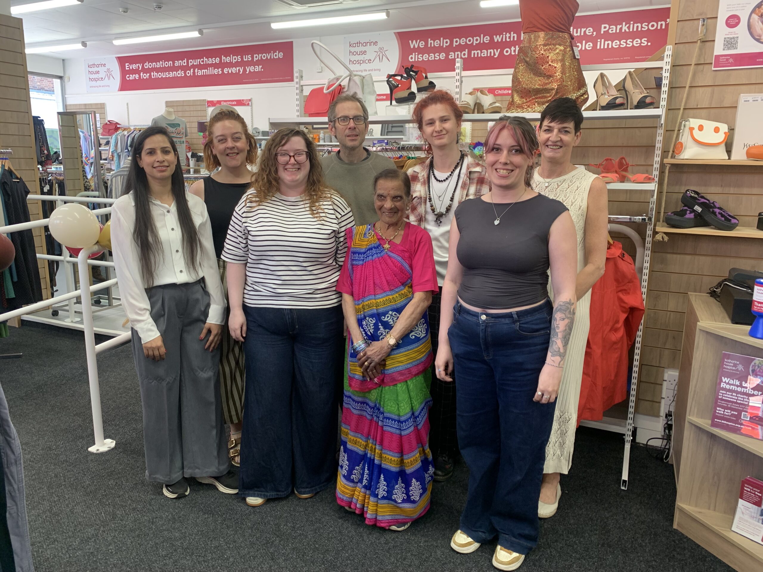 A group of eight staff and volunteers standing inside the shop
