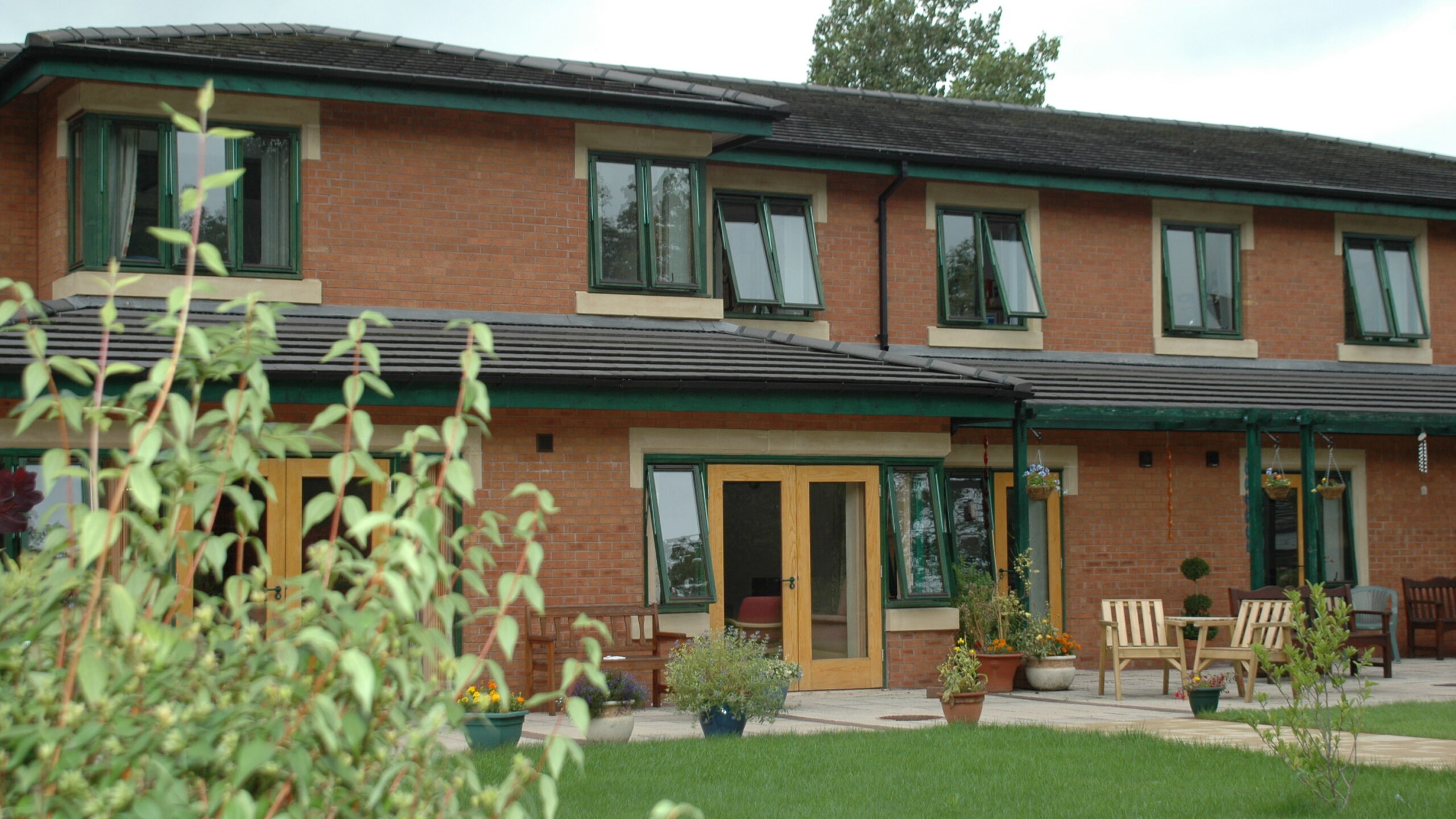 A two storey brick building with windows and glass doors