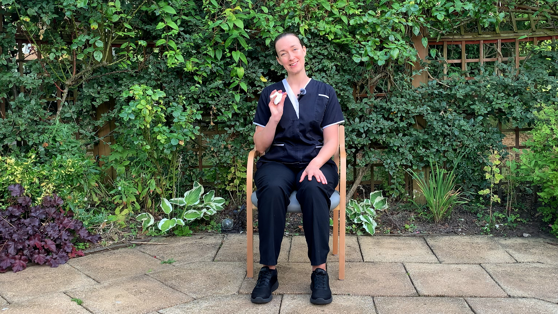 A woman sitting down and holding a 'squeezy star' stress relief object.
