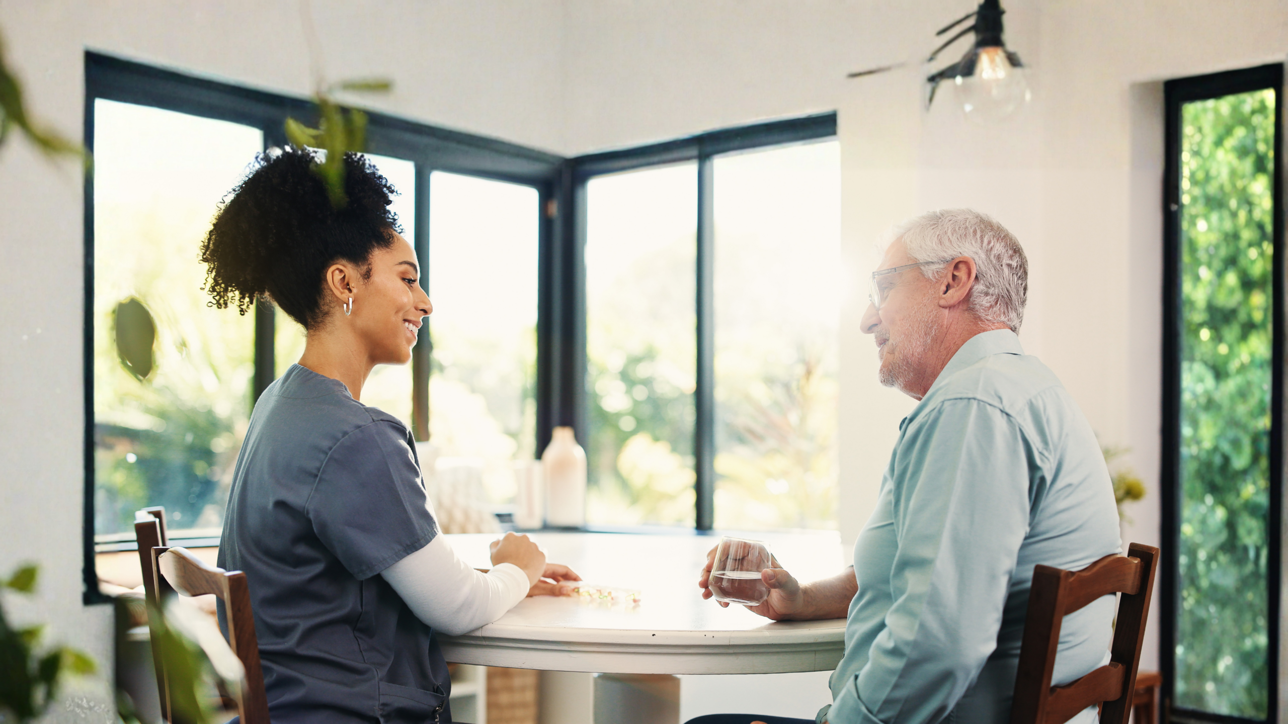 A man talking with a nurse at a table.
