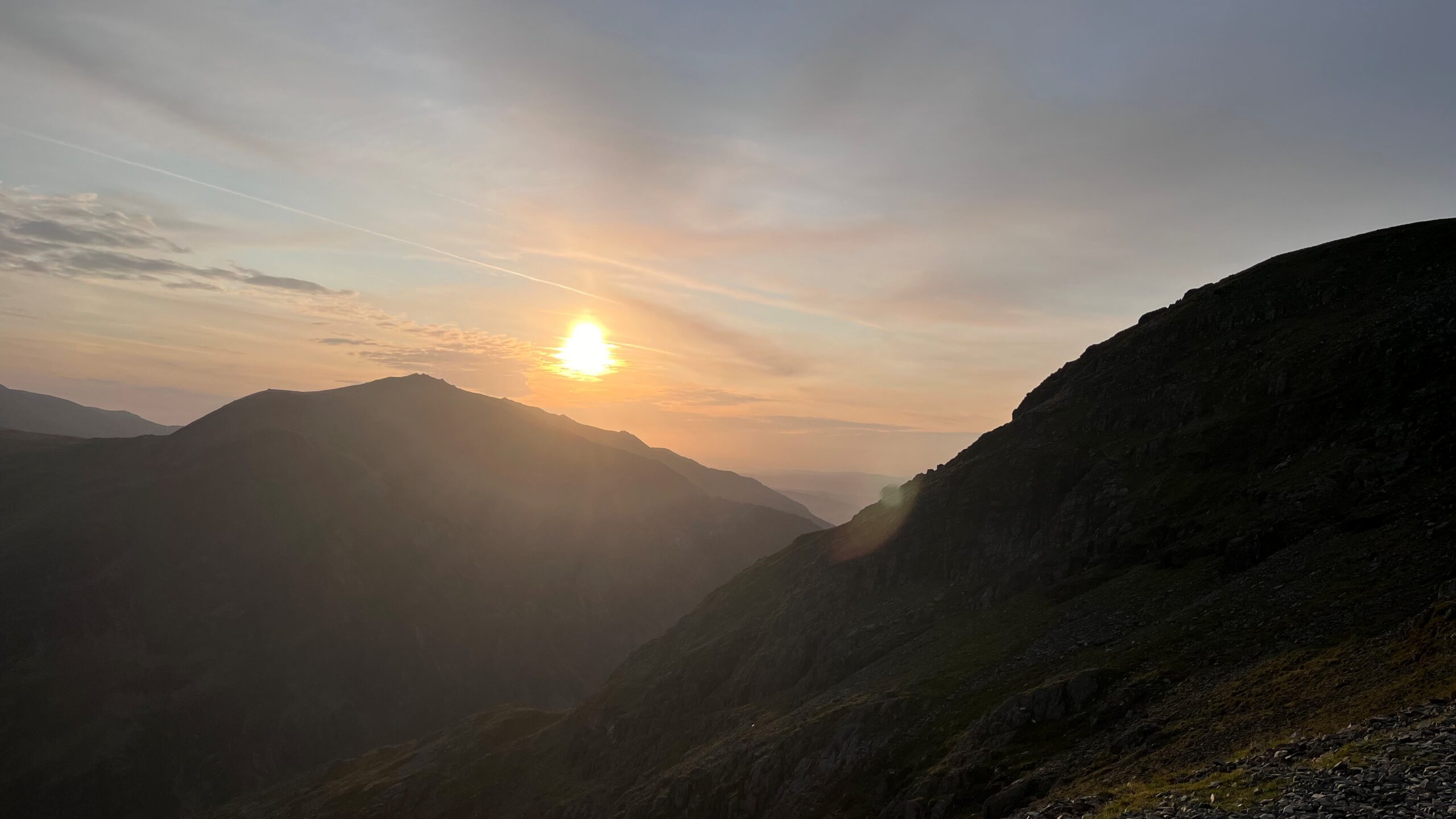 The sun rising over dark mountains