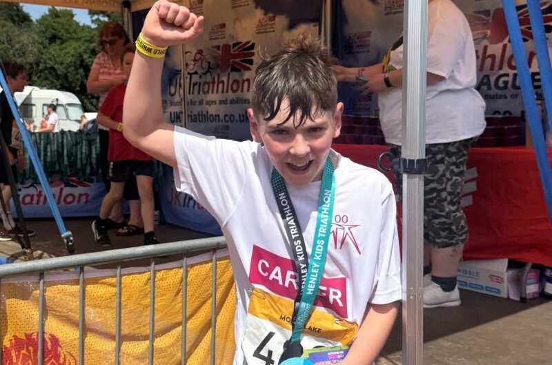 Carter celebrates with his triathlon medal.