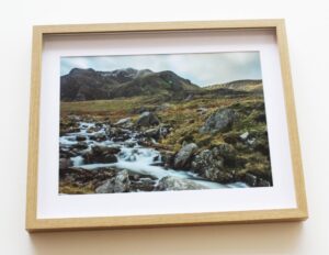 A framed photo of a river flowing through the countryside.